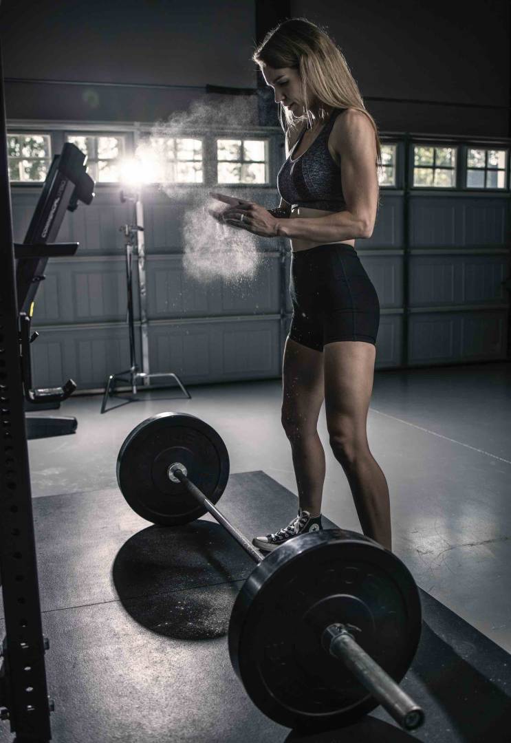 Woman Preparing To Lift Weights In A Garage